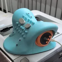 Imagem enviada pelo cliente. Clique para ver mais detalhes. A imagem representa: Um dispositivo de máscara facial LED azul claro com botões de controle e display digital colocado em uma superfície branca