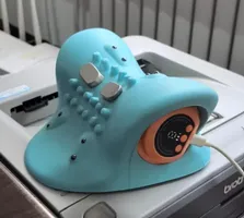 Imagem enviada pelo cliente. Clique para ver mais detalhes. A imagem representa: Um dispositivo de máscara facial LED azul claro com botões de controle e display digital colocado em uma superfície branca